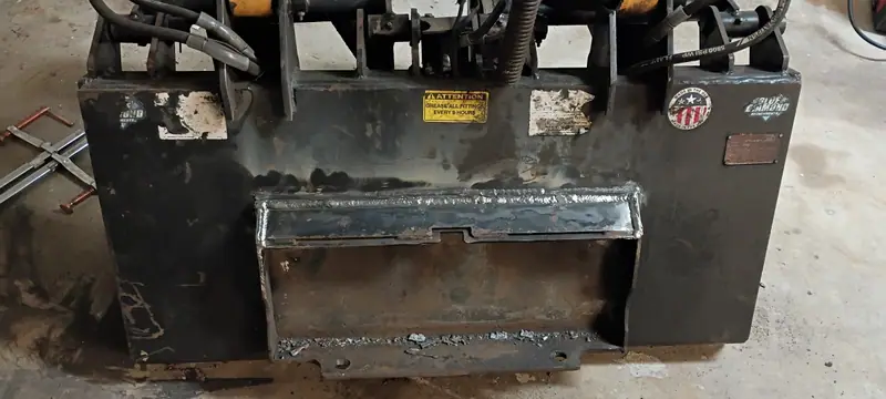 Skid steer attachment plate with a new welded reinforcement